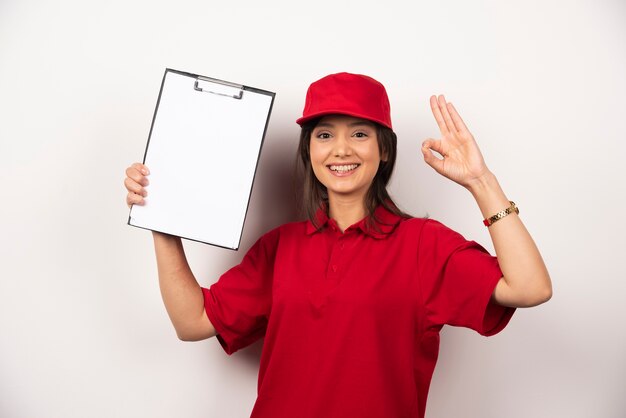 Femme positive en uniforme rouge avec presse-papiers vide