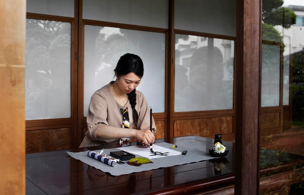 Photo gratuite femme pratiquant l'écriture japonaise