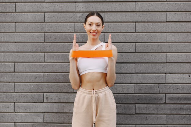 Femme pratiquant le yoga avancé contre un mur urbain sombre