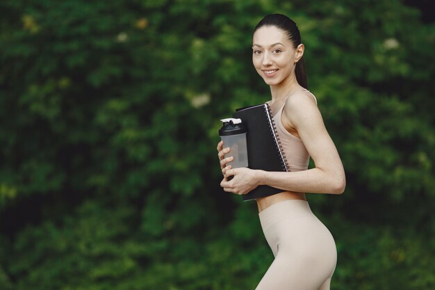 Femme pratiquant le yoga avancé dans un parc d'été