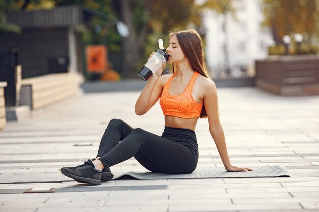 Femme pratiquant le yoga avancé dans une ville d'été