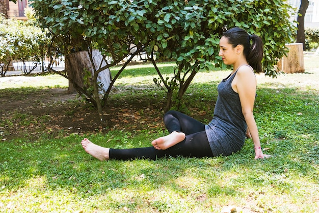 Femme pratiquant le yoga dans le parc