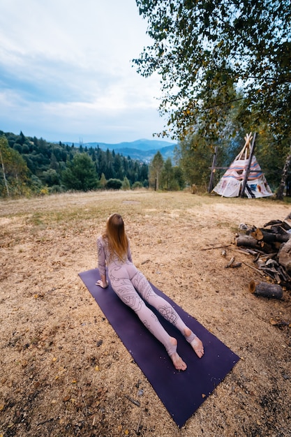 Photo gratuite une femme pratique le yoga le matin dans un parc au grand air.