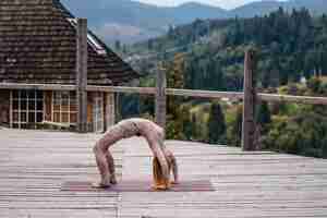 Photo gratuite une femme pratique le yoga le matin sur une terrasse au grand air.
