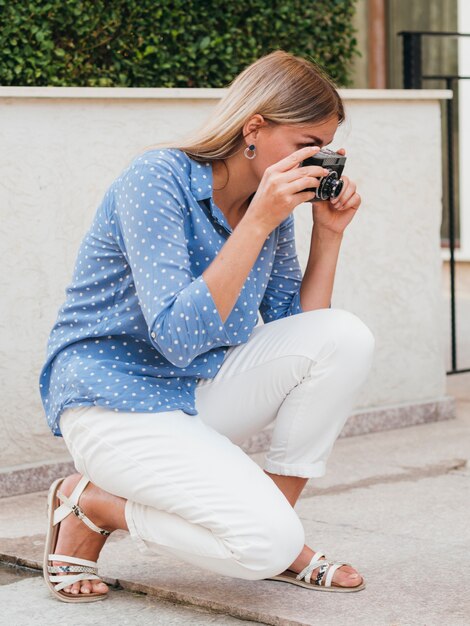 Femme prenant une caméra en plein air