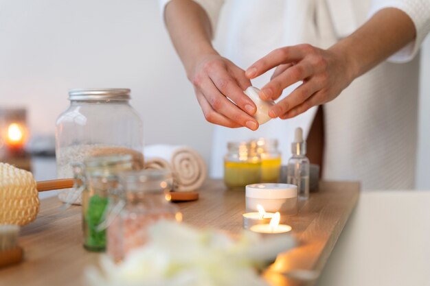 Femme prenant la crème hydratante pour l'appliquer sur son visage avant de prendre un bain