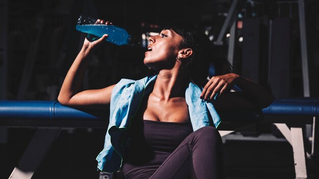 Femme prenant une pause en salle de sport