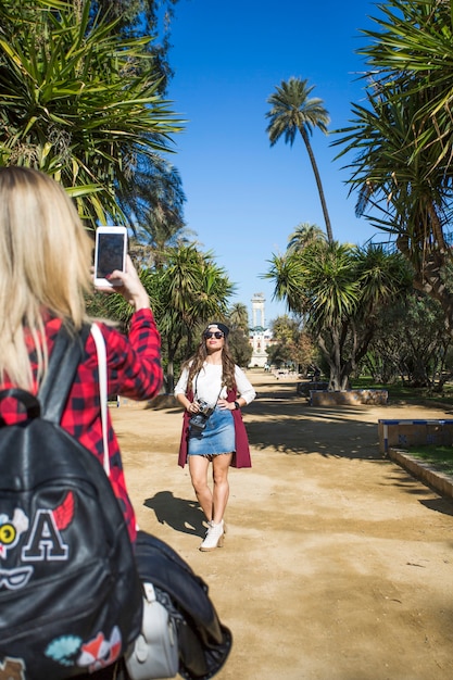 Femme prenant la photo d&#39;un ami dans le parc