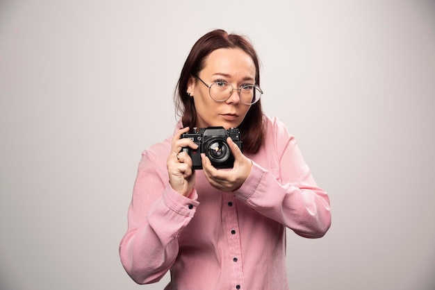 Femme prenant une photo avec appareil photo sur blanc. photo de haute qualité