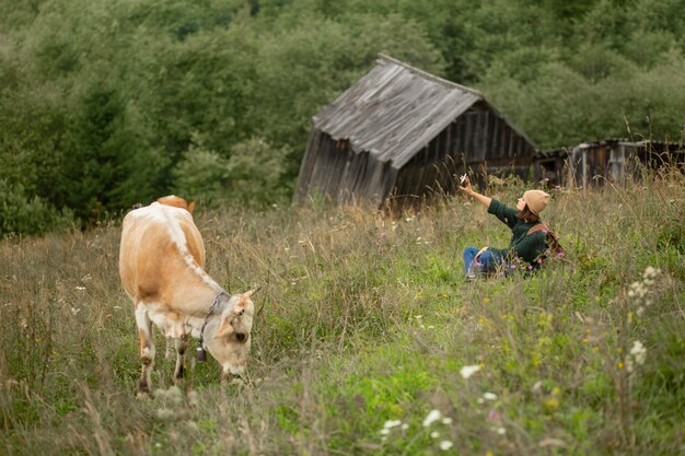 Femme prenant une photo à côté d'une vache