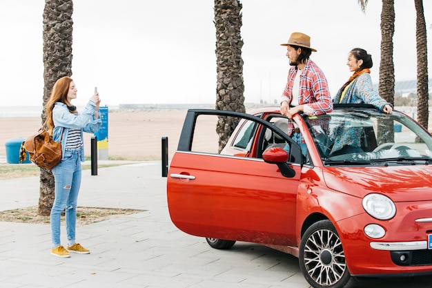 Femme prenant une photo d&#39;un couple en voiture