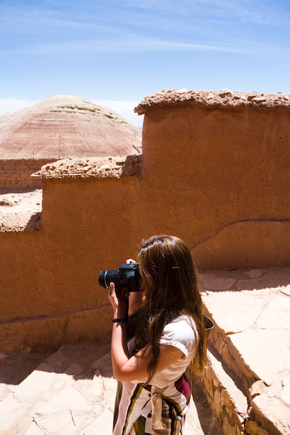 Femme prenant une photo dans les ruines du désert