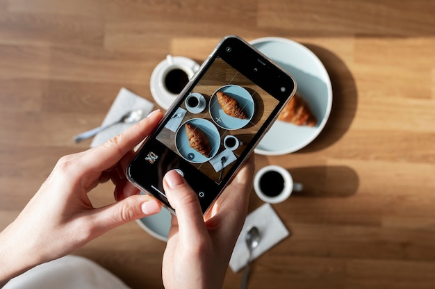 Photo gratuite femme prenant une photo de deux croissants