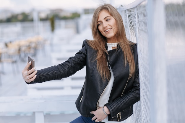 Femme prenant une photo d&#39;elle-même en souriant