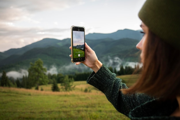 Femme prenant une photo de l'environnement rural