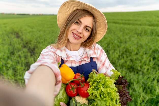 Femme prenant une photo avec des légumes
