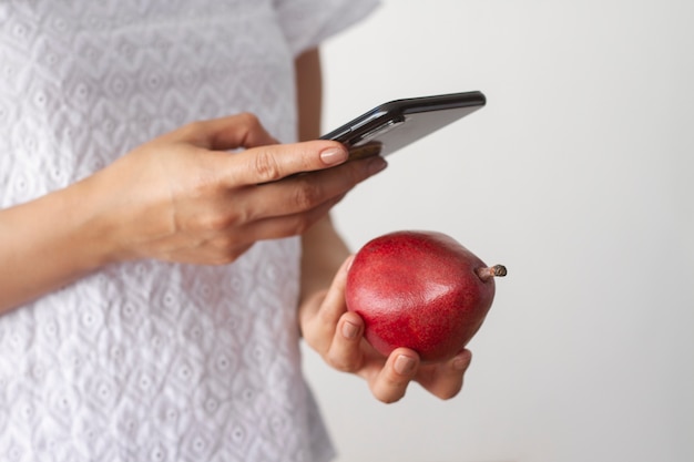 Photo gratuite femme prenant une photo de poire avec un smartphone