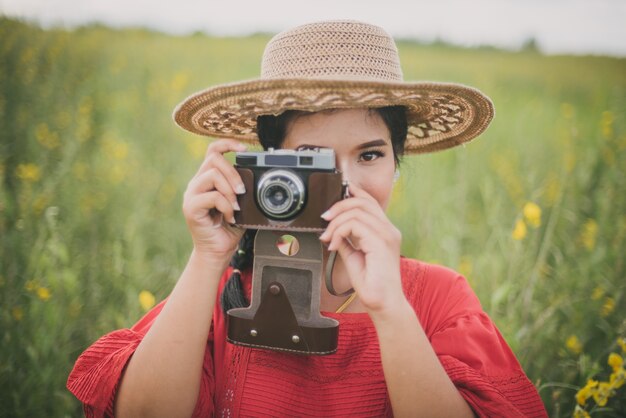 Femme prenant une photo avec un vieil appareil photo