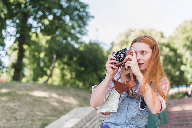 Photo gratuite femme prenant la photo avec le vieil appareil photo