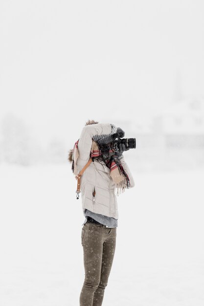 Femme prenant des photos en hiver