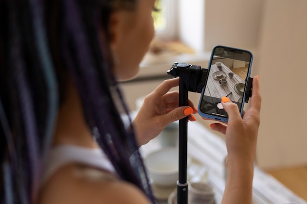 Femme prenant des photos pour son entreprise avec des ustensiles de cuisine en céramique