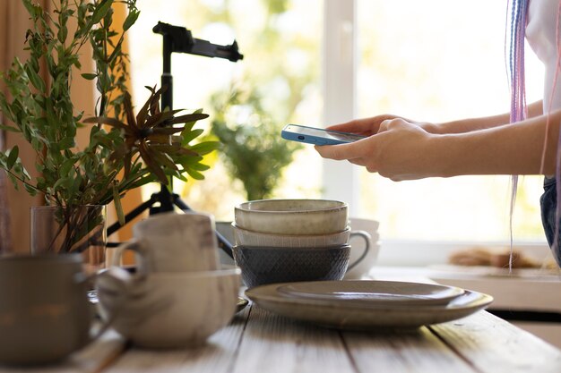 Femme prenant des photos d'ustensiles de cuisine en céramique