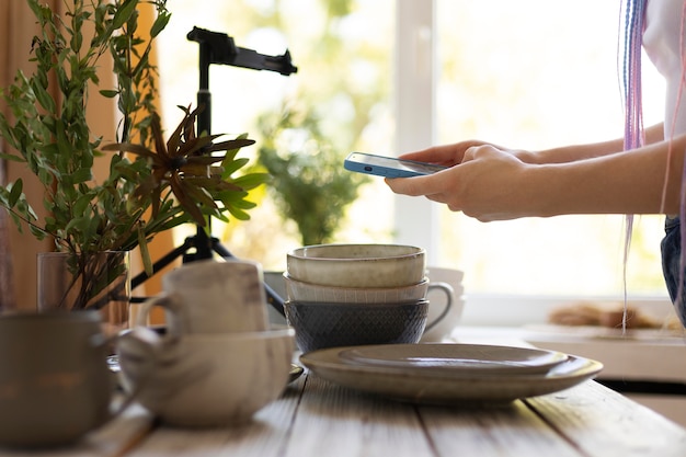 Femme prenant des photos d'ustensiles de cuisine en céramique