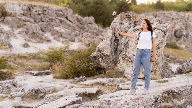 Femme prenant un selfie dans un bel endroit neuf avec copie espace