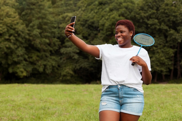 Femme prenant selfie à l'extérieur avec raquette