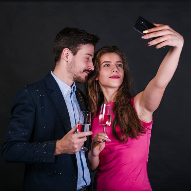 Femme prenant selfie avec homme en fête