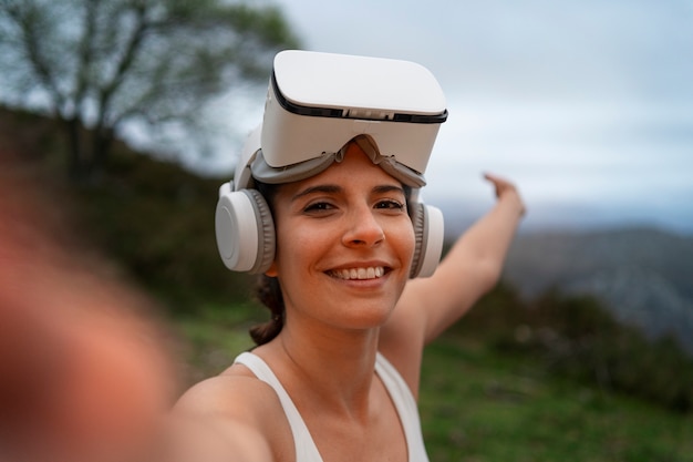 Femme prenant selfie pendant l'exercice avec des lunettes vr à l'extérieur dans la nature