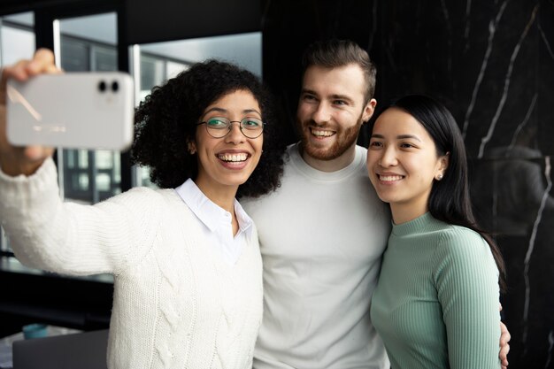 Femme prenant un selfie avec ses collègues