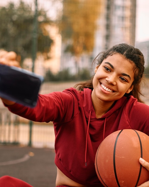Femme prenant un selfie avec son ballon de basket