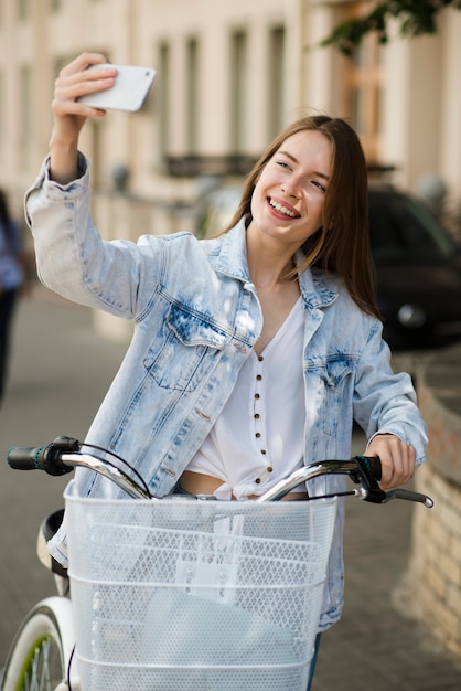 Photo gratuite femme prenant un selfie avec son vélo