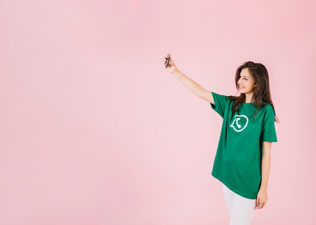 Photo gratuite femme prenant selfie sur téléphone portable portant le t-shirt d'icône whatsapp