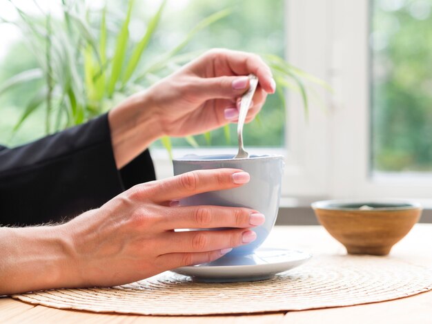 Femme, Prendre, cuillère à café, tasse thé