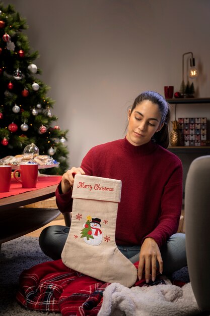 Femme préparant des chaussettes géantes pour que le père Noël puisse laisser des cadeaux