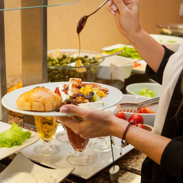 Femme préparant un délicieux repas dans une cuisine. vue de côté.