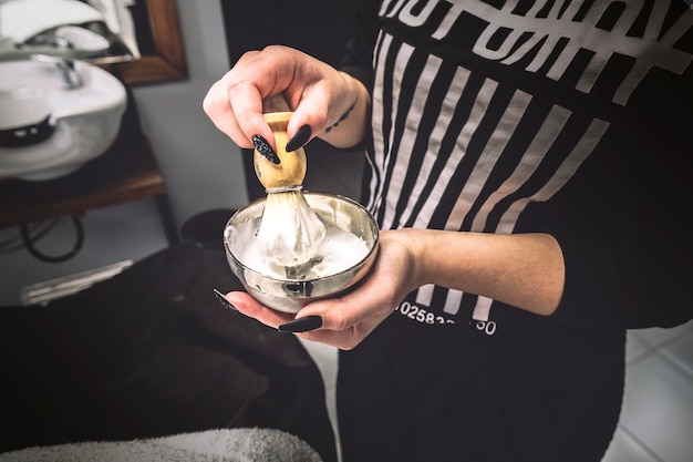 Femme préparant la mousse dans le salon de coiffure