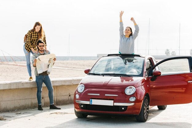 Femme, près, homme, regarder, carte, et, positif, dame, pencher dehors, de, voiture, plage