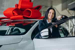 Photo gratuite femme près de la voiture avec grand arc rouge