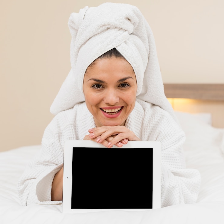 Photo gratuit femme présentant une tablette dans une chambre d&#39;hôtel
