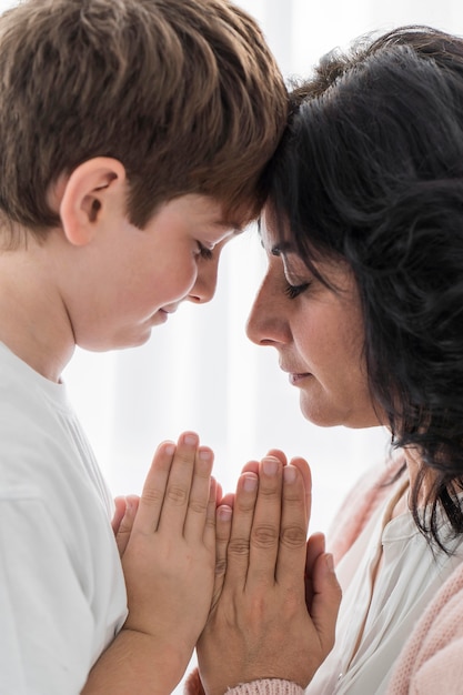 Femme priant avec son garçon