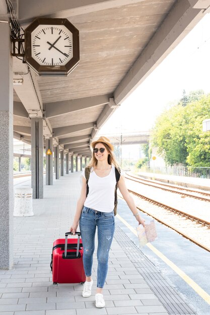 Femme promenant ses bagages partout dans la gare