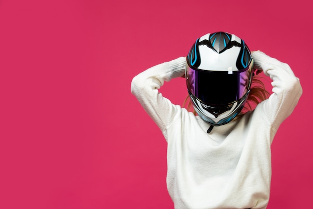 Femme en pull blanc avec casque de moto