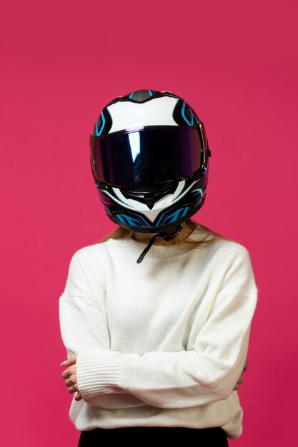 Femme en pull blanc avec casque de moto