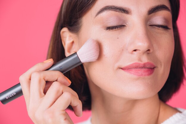 Femme en pull blanc décontracté sur mur rouge