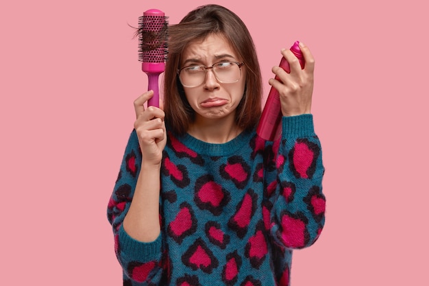 Femme en pull coloré faisant sa coiffure