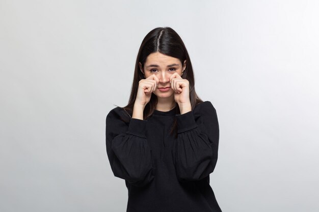 Femme en pull noir montre le visage de pleurer