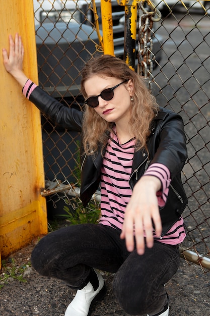 Femme punk avec des lunettes de soleil en milieu urbain